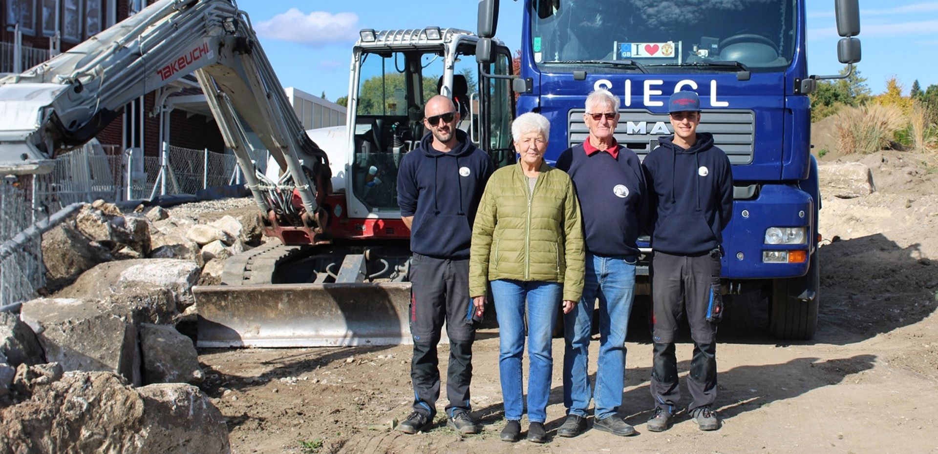 Das Team von Siegl vor einem Firmen-LKW auf einer Baustelle
